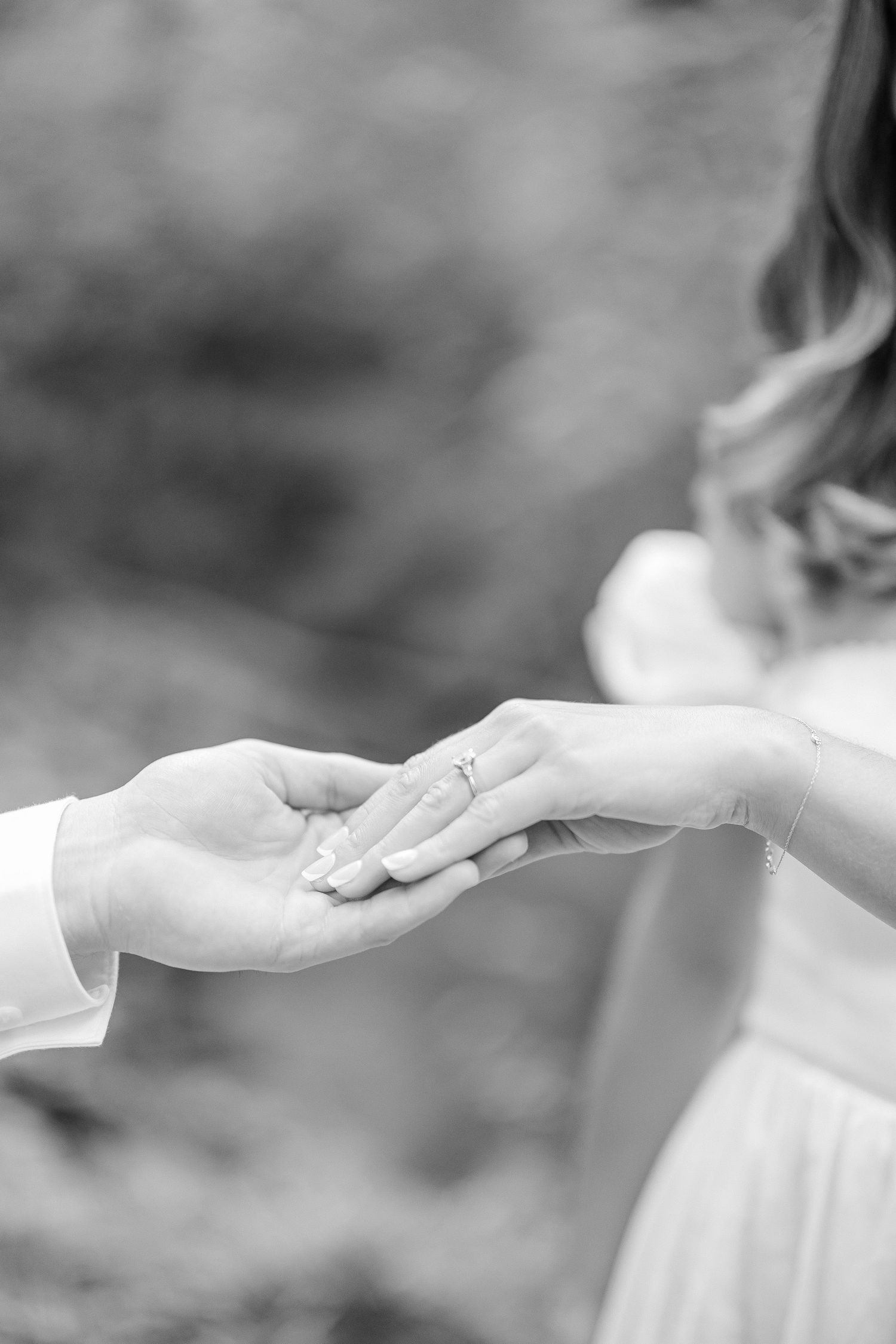 Black and white image showing two hands reaching out towards each other in a gentle, graceful motion.