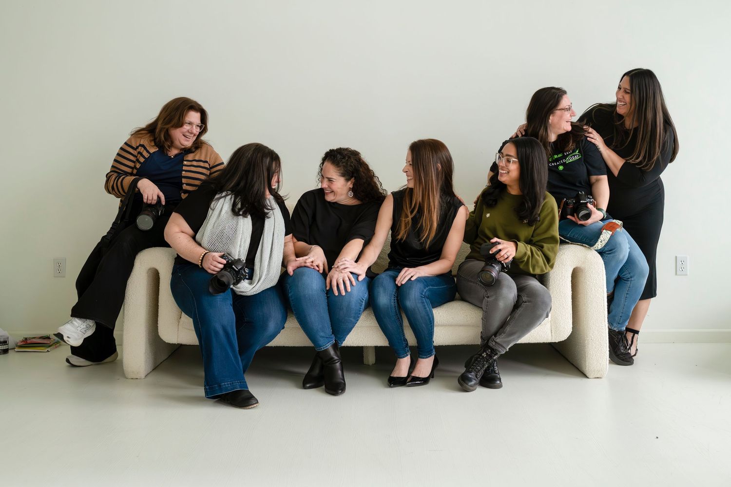 Group of people sitting casually on white bench during informal gathering.