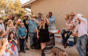 Guests socializing and having fun at an outdoor party with lattice decorations and natural lighting.