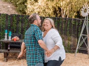Sweet moment shared between couple in outdoor venue with teal accents and string lighting.