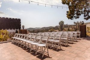 White folding chairs arranged in rows for an outdoor desert wedding ceremony.