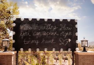 Chalkboard signs with handwritten messages displayed at an outdoor venue.