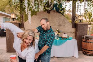 Casual outdoor celebration scene with joyful moments captured under a wooden pergola.