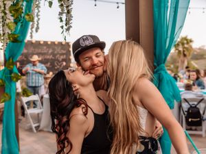 Candid celebration moments between friends at an outdoor venue with teal accents.