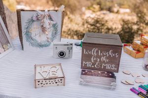 Wedding signage and decorative details displayed on rustic wooden table.