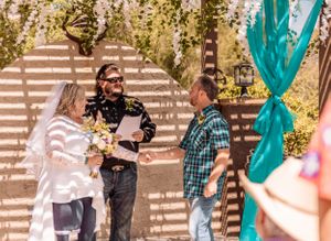 Wedding celebration in an outdoor venue with turquoise decorations and hanging floral elements.