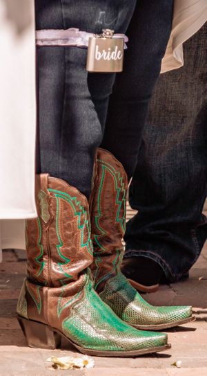 Close-up of brown and green snakeskin cowboy boots at a wedding.