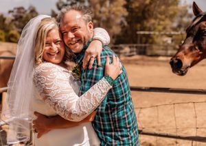 A tender embrace between newlyweds at a countryside ranch setting.