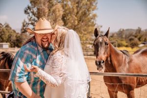 Candid wedding moments captured in a rustic ranch setting with horses.
