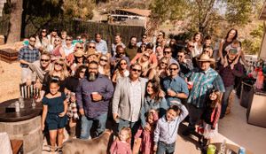 Large group of people celebrating at an outdoor western-themed event.