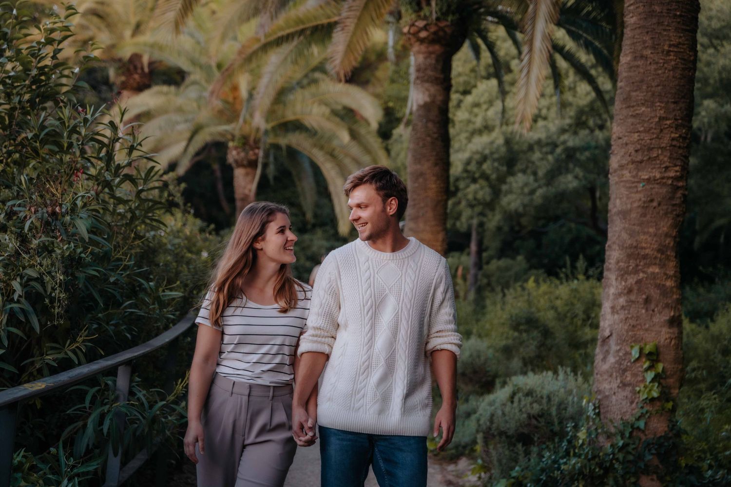 Wide shot of couple framed by the architectural viaducts of the park.
