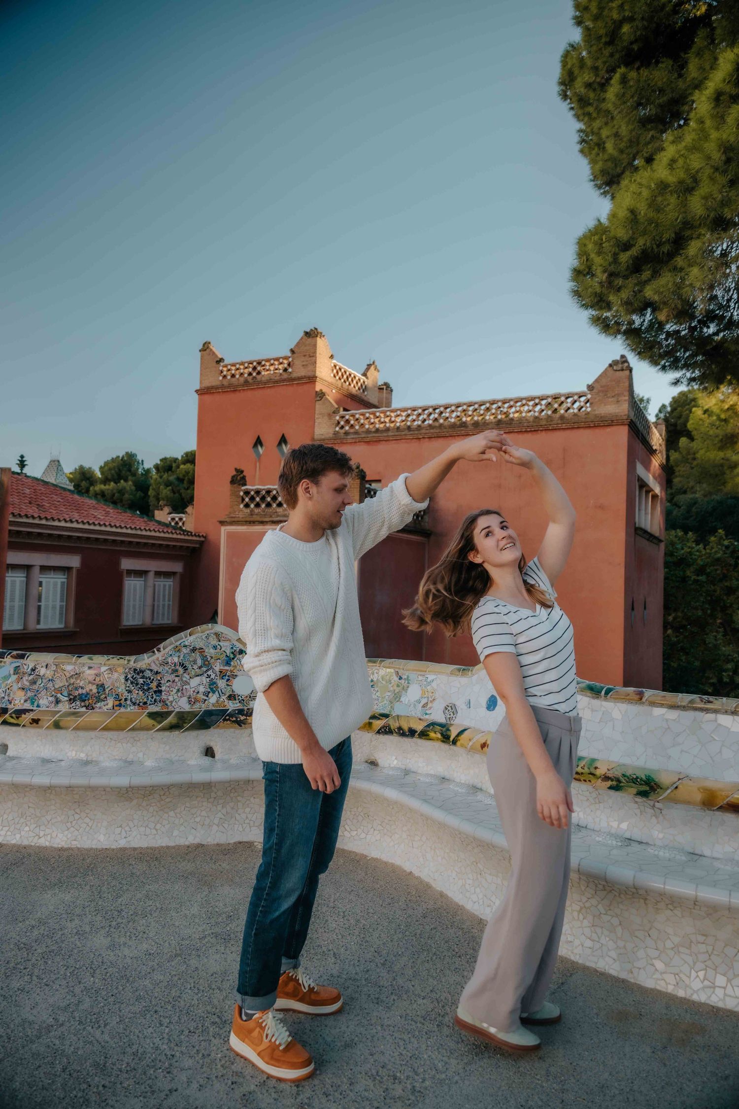 Romantic kiss with the gingerbread houses of Park Güell in background.