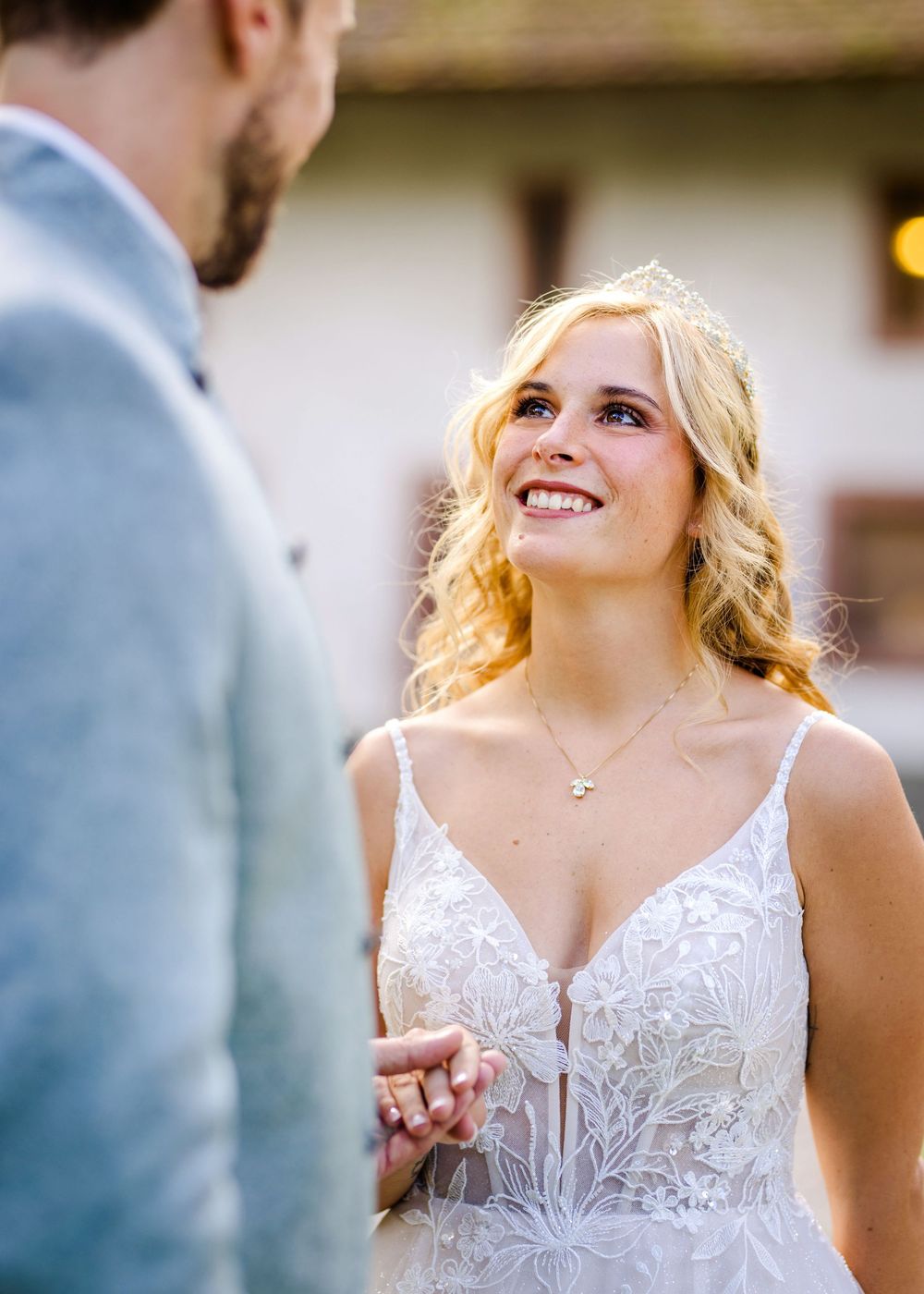 Close-up shots of bride in delicate lace wedding dress with sweetheart neckline during outdoor ceremony.