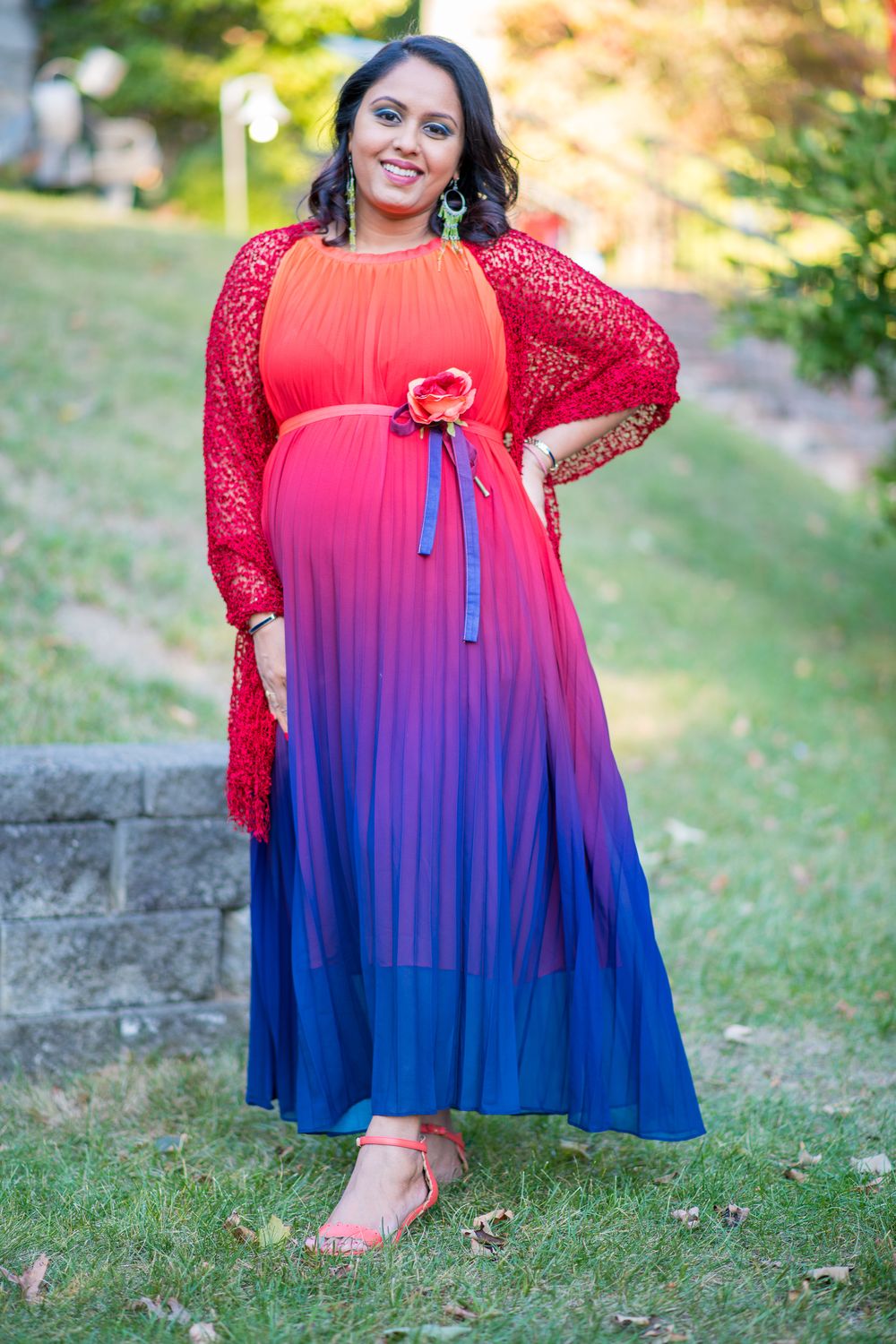 A vibrant ombre dress transitions from coral red to deep blue with lace sleeves shown in multiple outdoor photos.