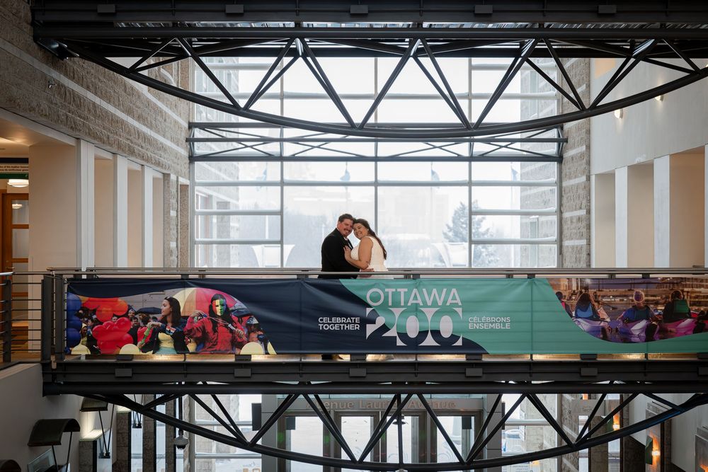 A person lies relaxed on an elevated platform with Ottawa branding in a modern indoor space.