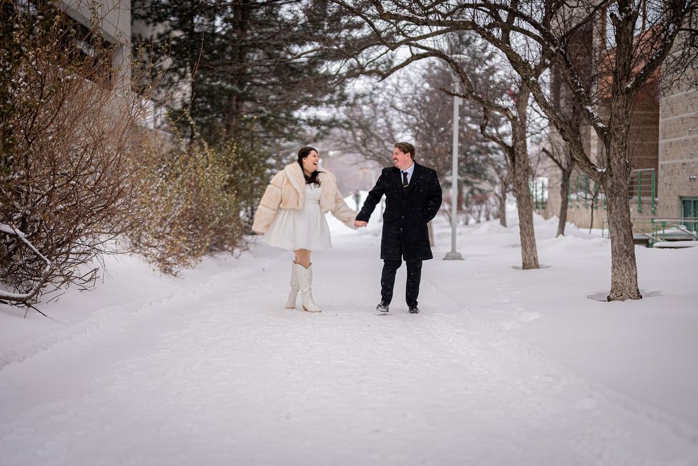 A couple shares romantic moments in a snowy winter landscape during their wedding photoshoot.