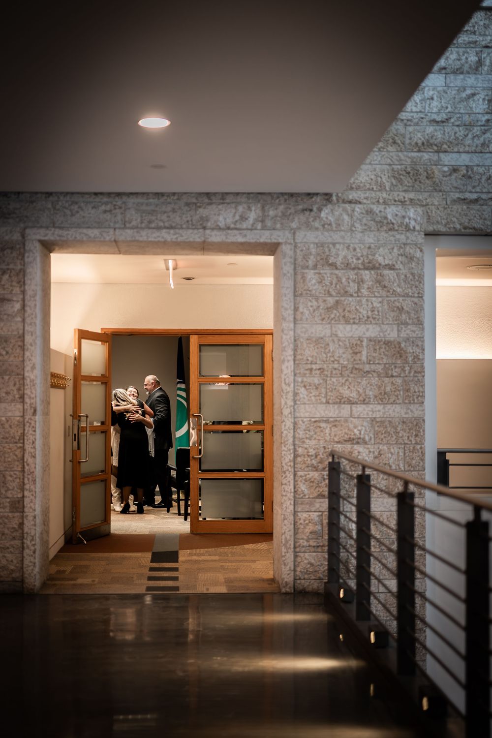 Modern concrete hallway with dramatic lighting and metal railings showcases minimalist architectural design.