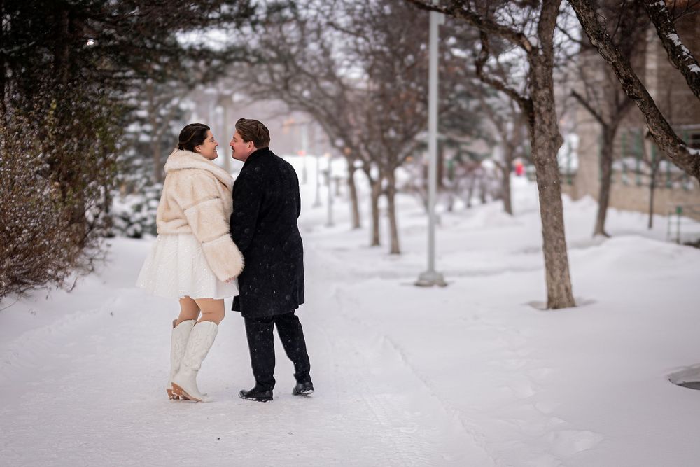 A couple shares romantic moments in a snowy winter landscape during their outdoor photoshoot.