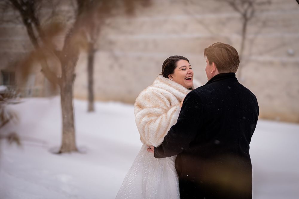 A couple shares intimate moments in a snowy winter landscape during their wedding photoshoot.