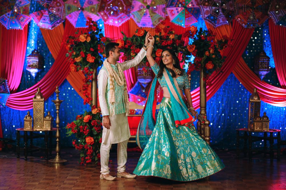 Multiple shots of someone twirling in a teal and gold traditional Indian outfit at an elegantly decorated event venue.