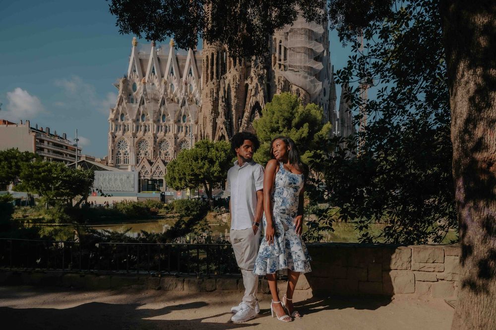 Elegant couple standing in front of Sagrada Familia towers sunny morning Barcelona.
