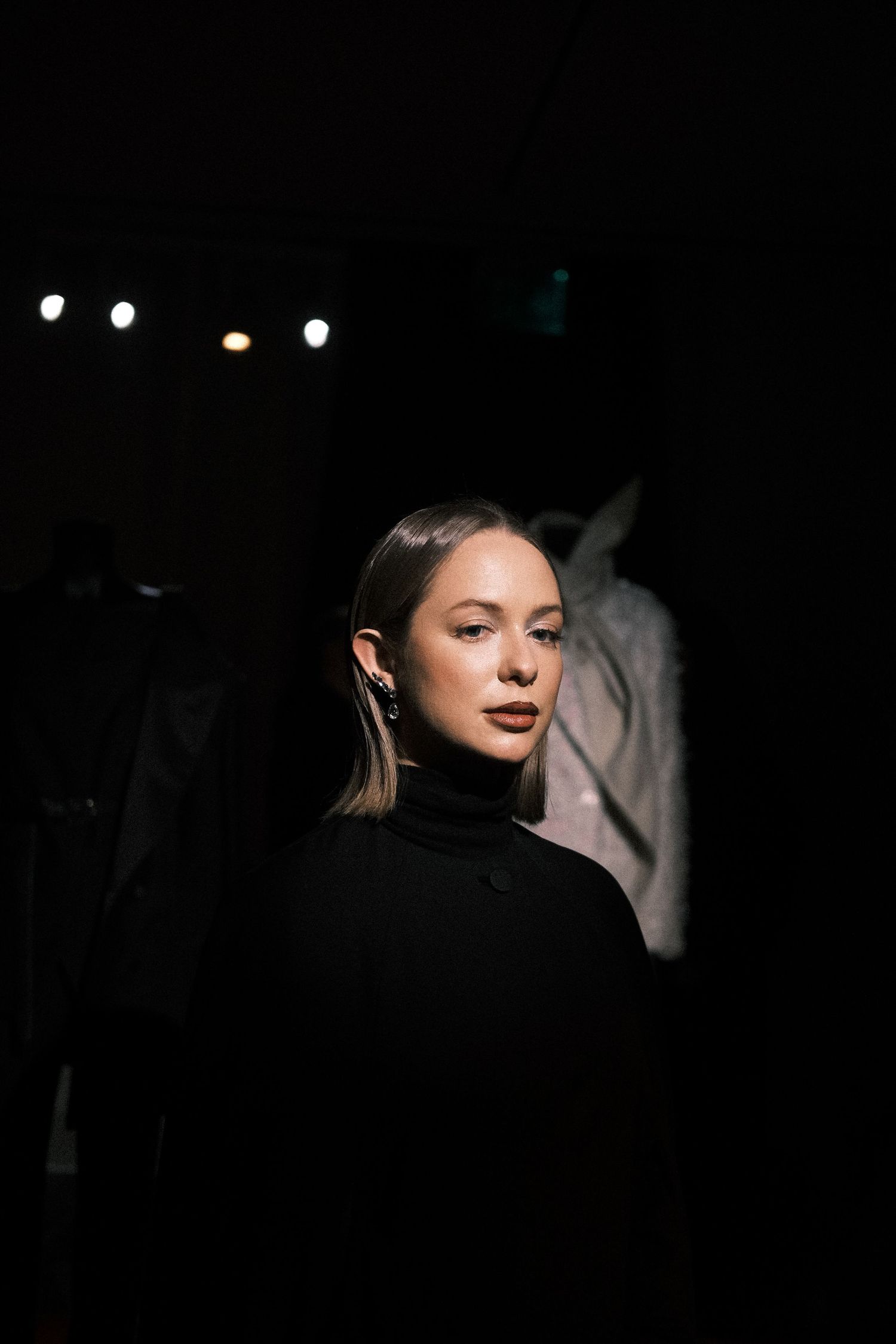 Dramatic side profile portrait in dark lighting with strong shadows creating a moody atmospheric effect.