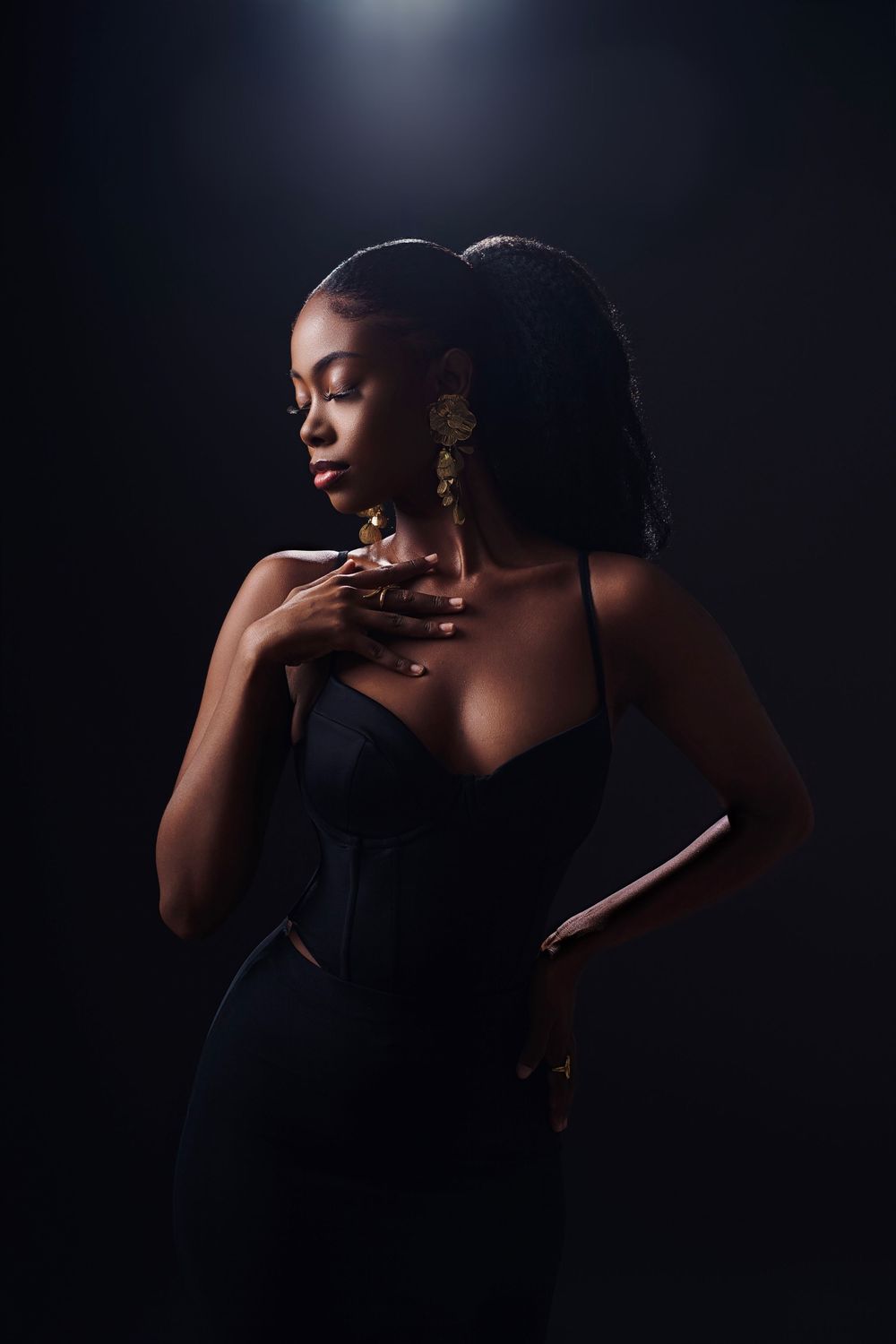Artistic black and white portrait series showing dramatic shadows and gold jewelry against dark background.