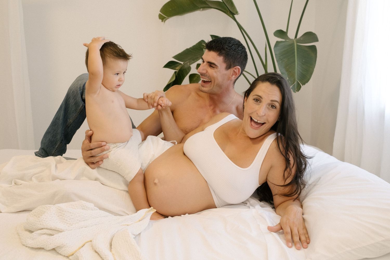 Collage of intimate family maternity photos showing tender moments between couple and baby bump in white bedroom setting.