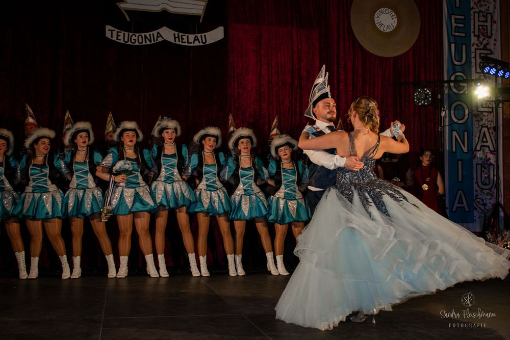 Ballet dancers in white tutus perform gracefully on a dimly lit stage during a classical dance recital.