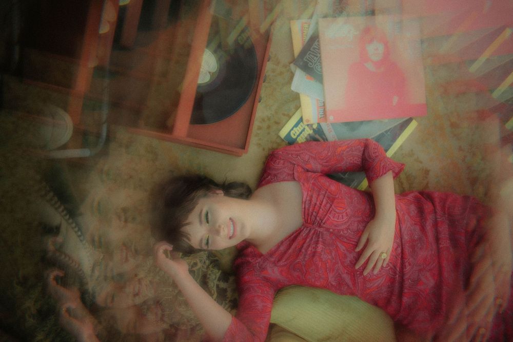Artistic portrait in red dress with dreamy double exposure effects.