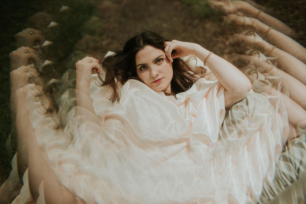 Artistic boudoir photography with flowing white fabric.