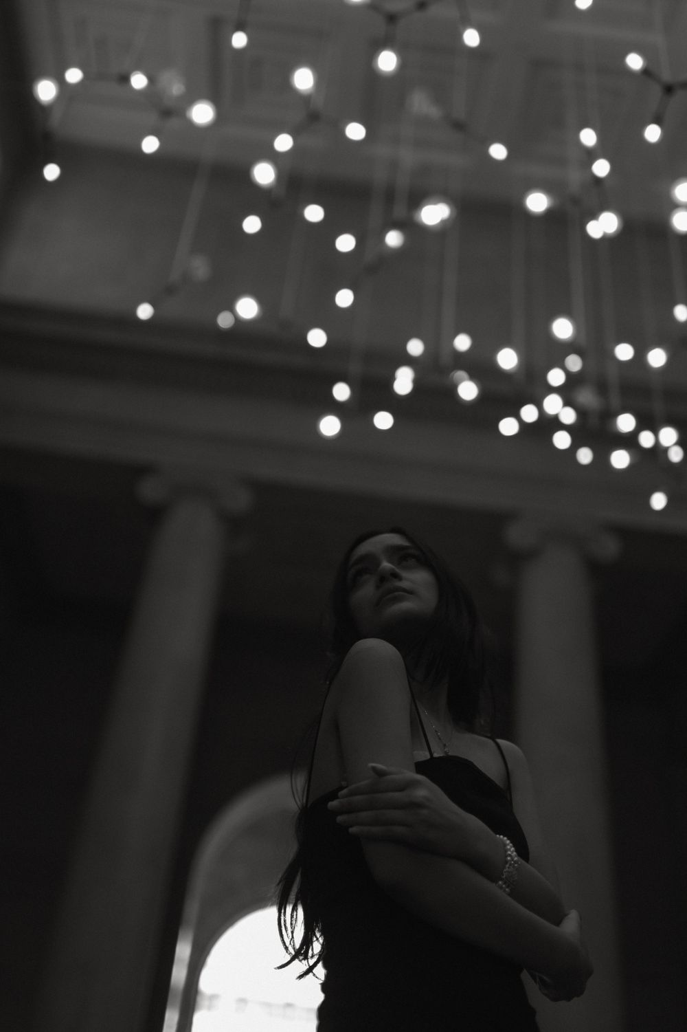 String lights create a dreamy bokeh effect in a dark indoor venue.