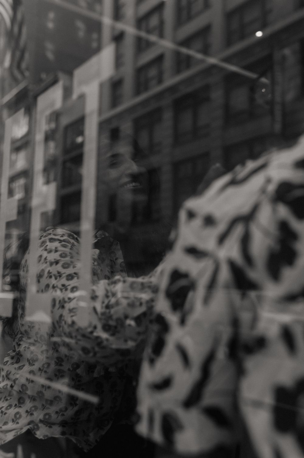 Abstract black and white urban reflection in window glass with blurred buildings.