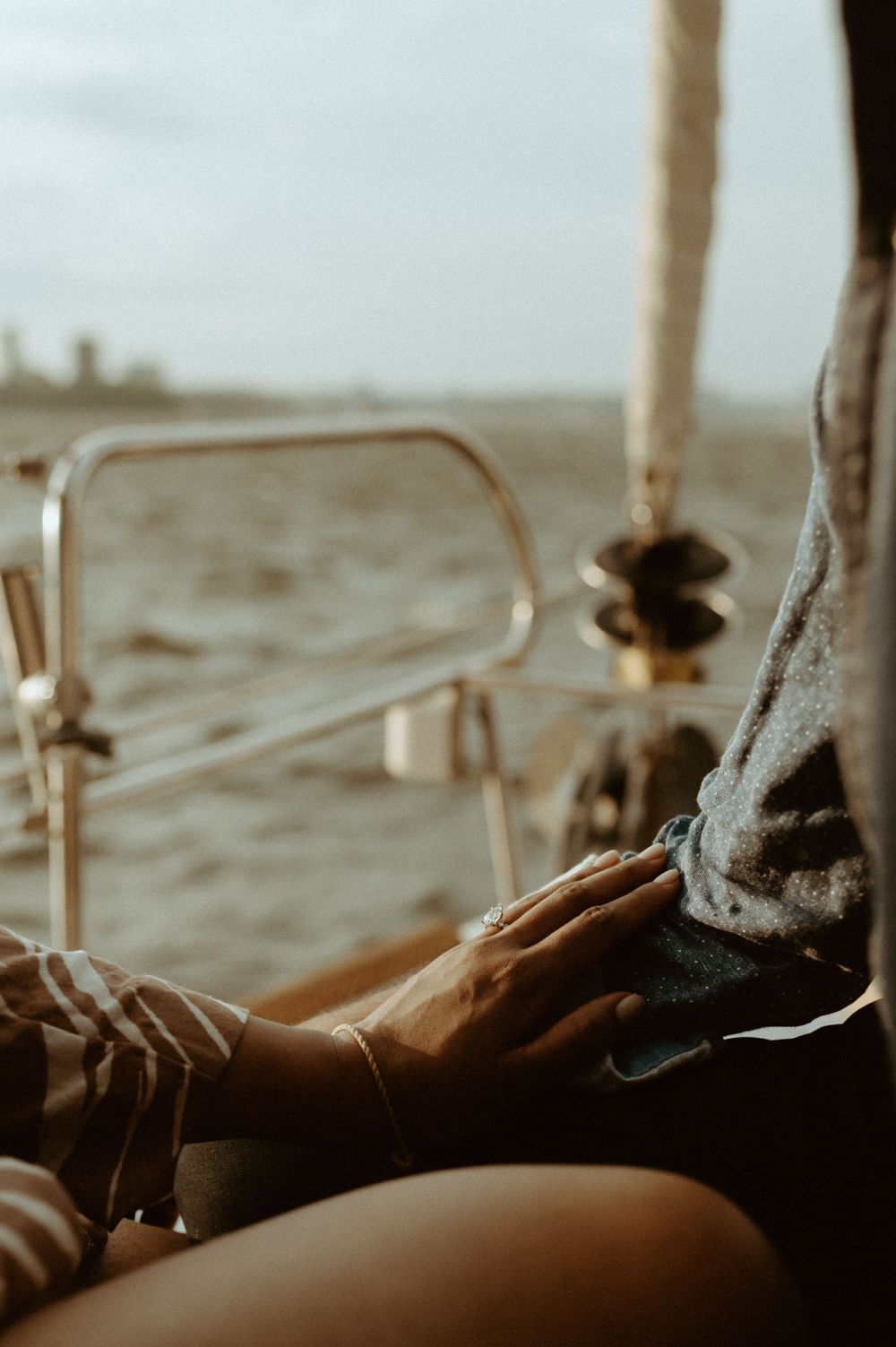 Feet propped up on a boat railing against a blurry ocean horizon.