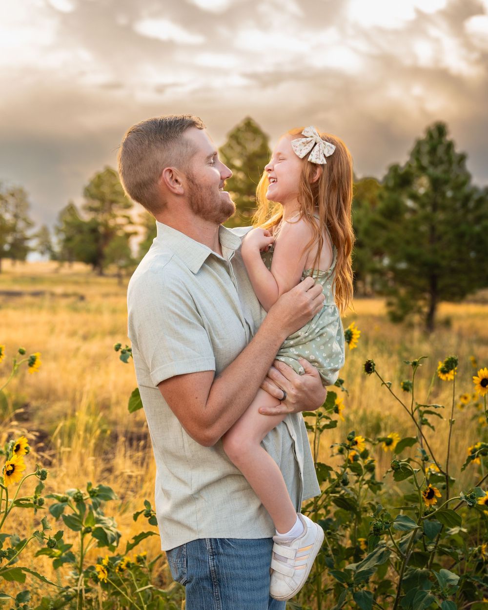 Intimate family moments captured in golden sunflower field at sunset.