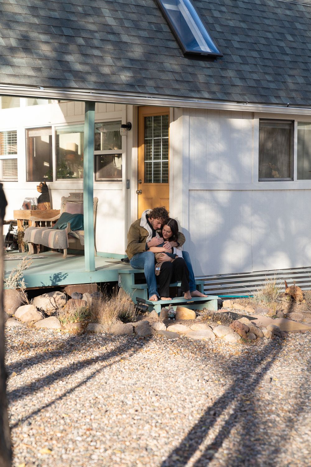 Candid outdoor portraits taken on a porch with gravel landscaping and white siding.
