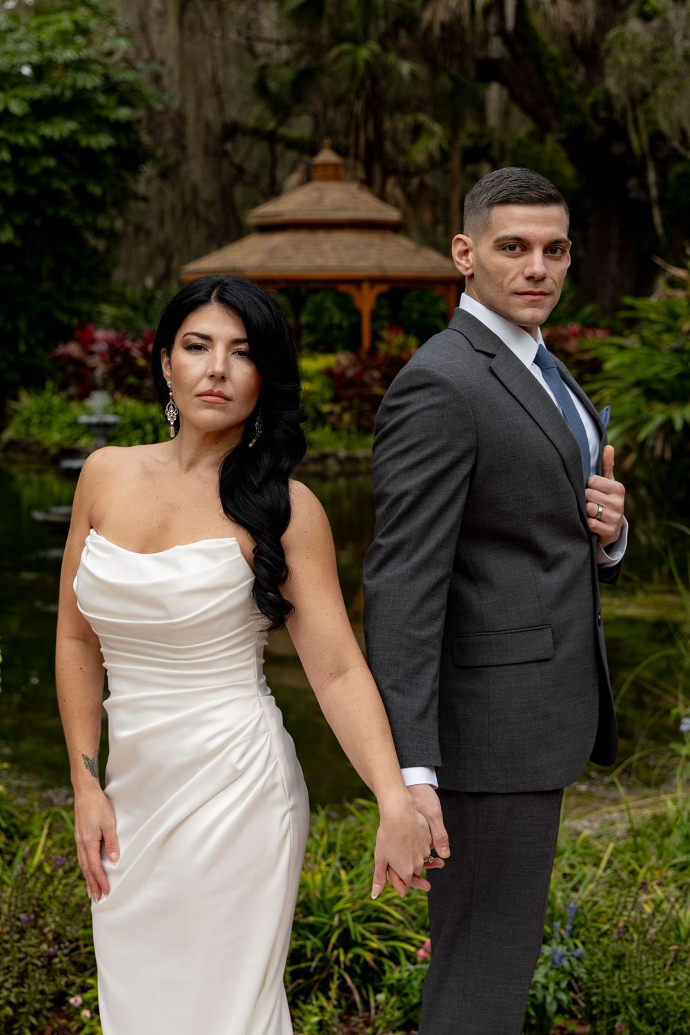 Artistic wedding portraits showing couple in formal attire against garden backdrop.