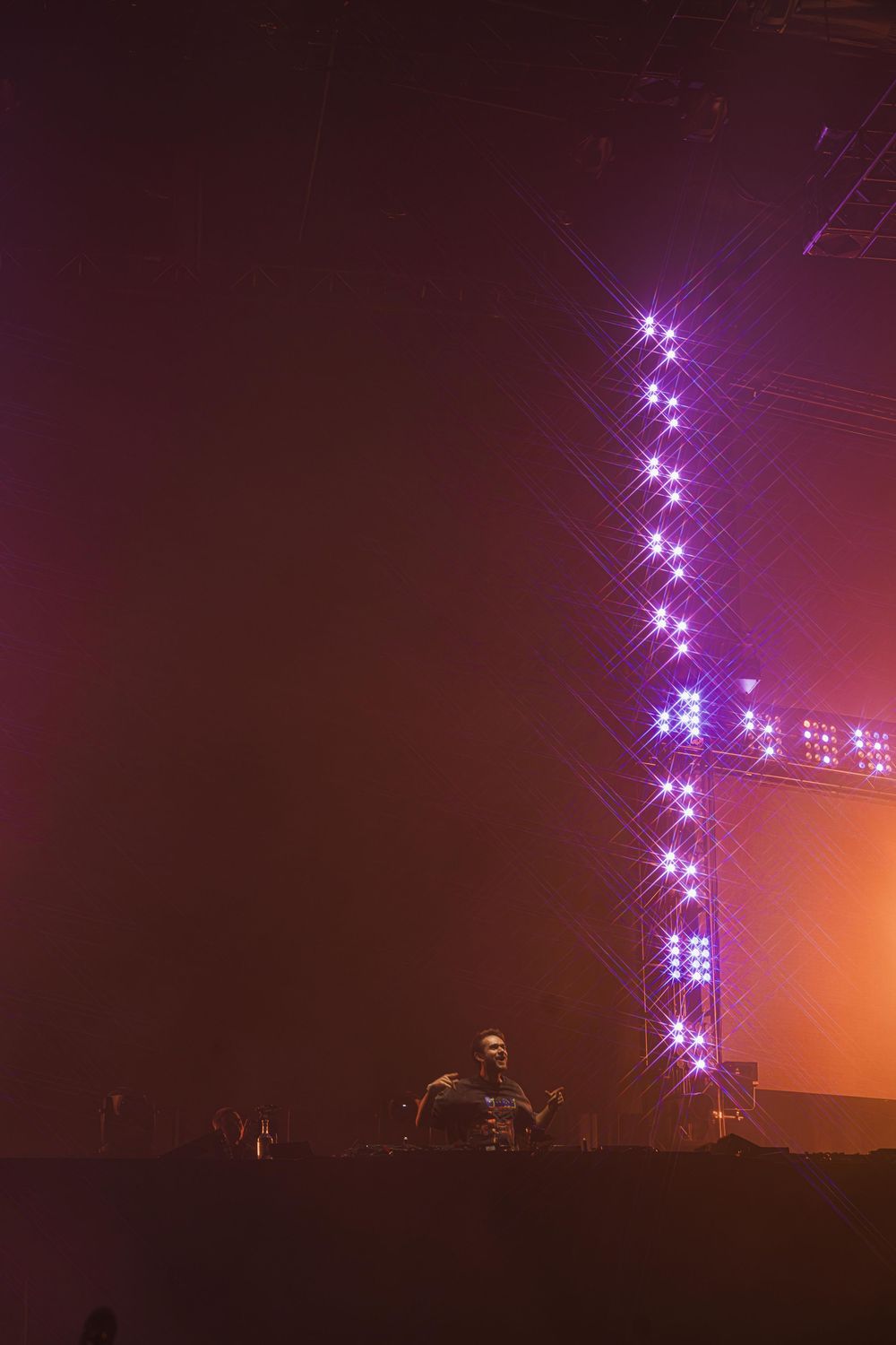 Stadium lights illuminate a foggy night sky with bright white beams creating a dramatic atmospheric effect.