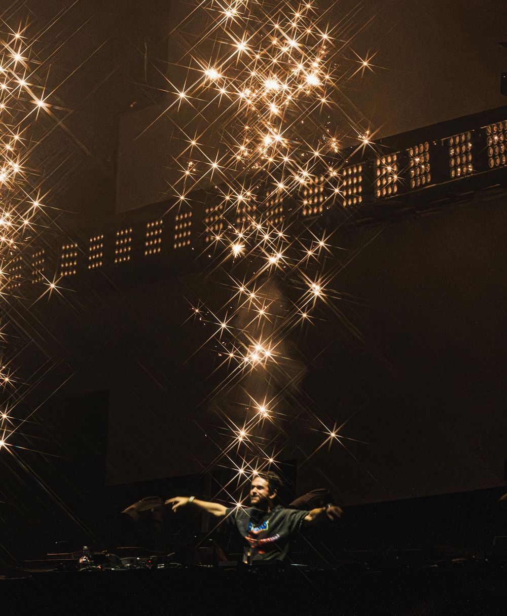 Twinkling lights create a magical starry effect against a dark background in a dramatic performance setting.