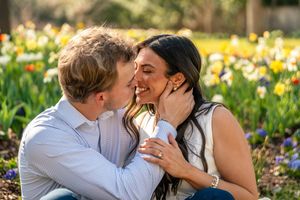 Couple sharing a romantic moment surrounded by colorful spring tulips in a garden.