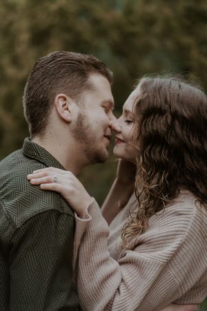Intimate close-up portrait of couple in cozy sweaters during autumn photoshoot.