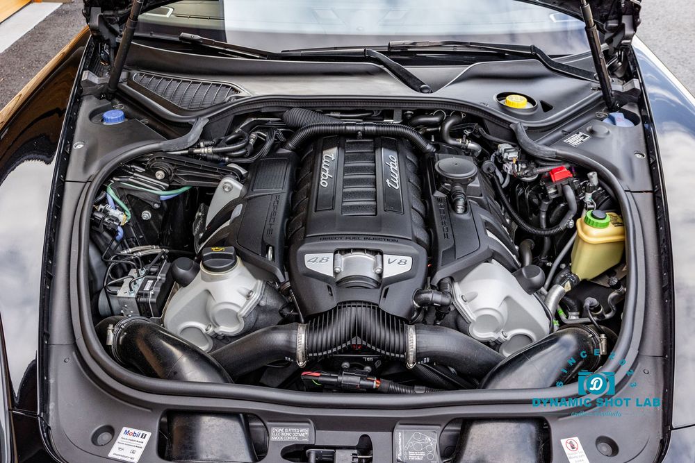 High-performance twin-turbocharged engine bay of a sports car, showcasing intricate components and carbon fiber intake.