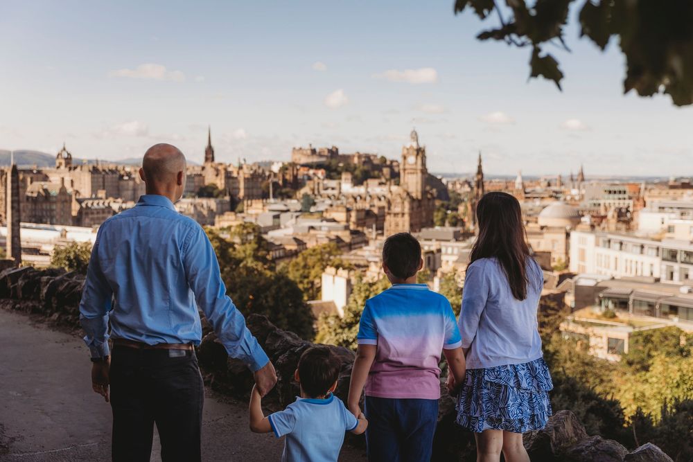 Group of people enjoying scenic city views from an elevated viewpoint during sunset in a European urban setting.