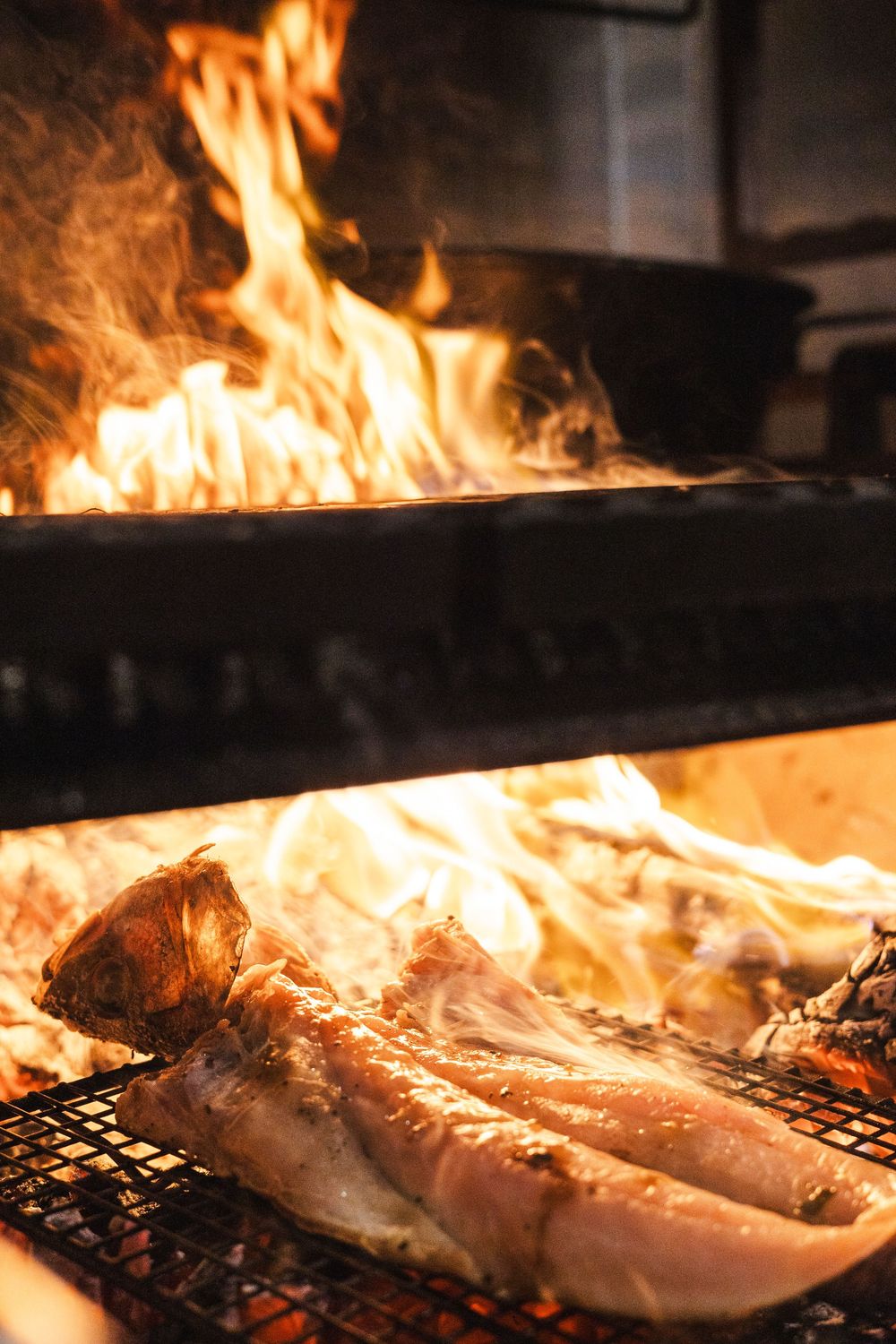 Fresh seafood grilling over open flames on a professional kitchen grill.