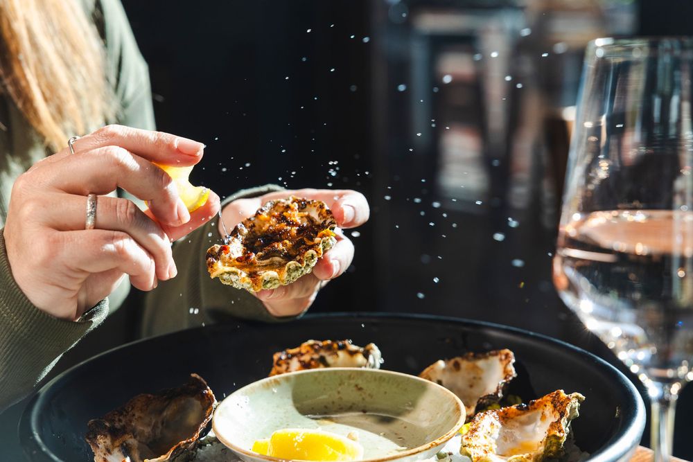 Close-up shots of hands preparing and serving delicious gourmet dishes in a restaurant setting.