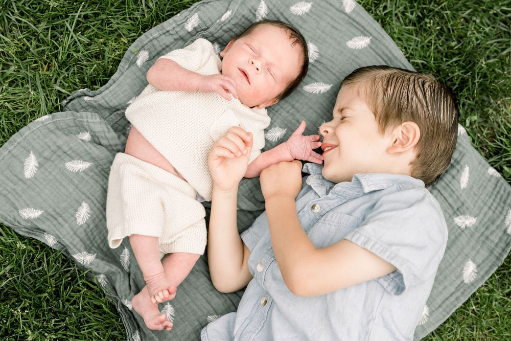 A series of sweet candid moments captured on a gray blanket in the grass on a sunny day.