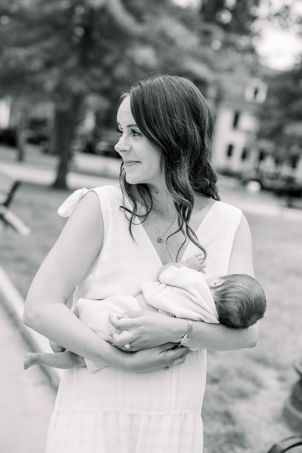 A series of black and white photos showing tender moments of breastfeeding in an outdoor setting.
