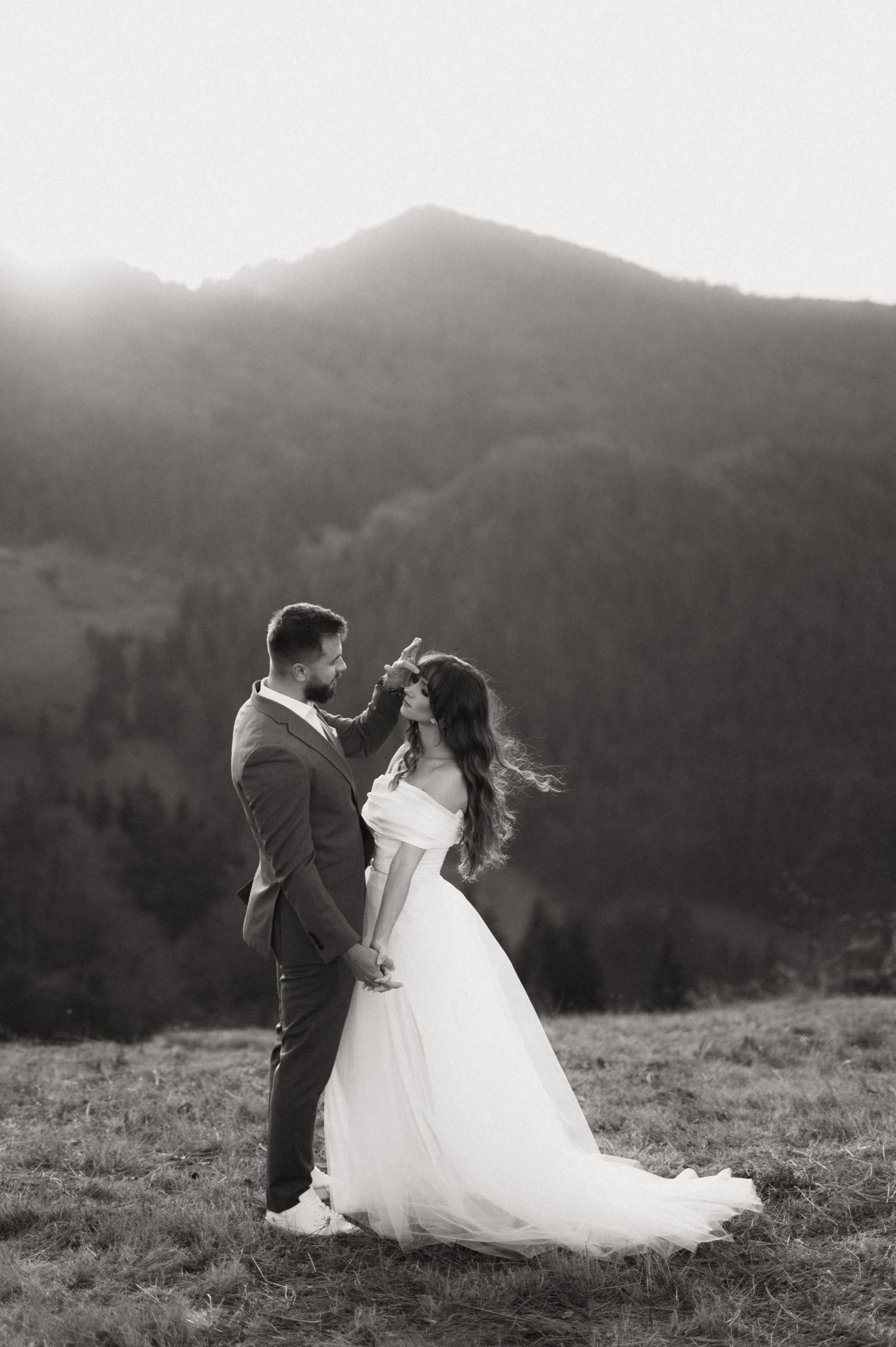 A romantic black and white wedding photo sequence shows a couple dancing together on a hilltop with mountains in the background.