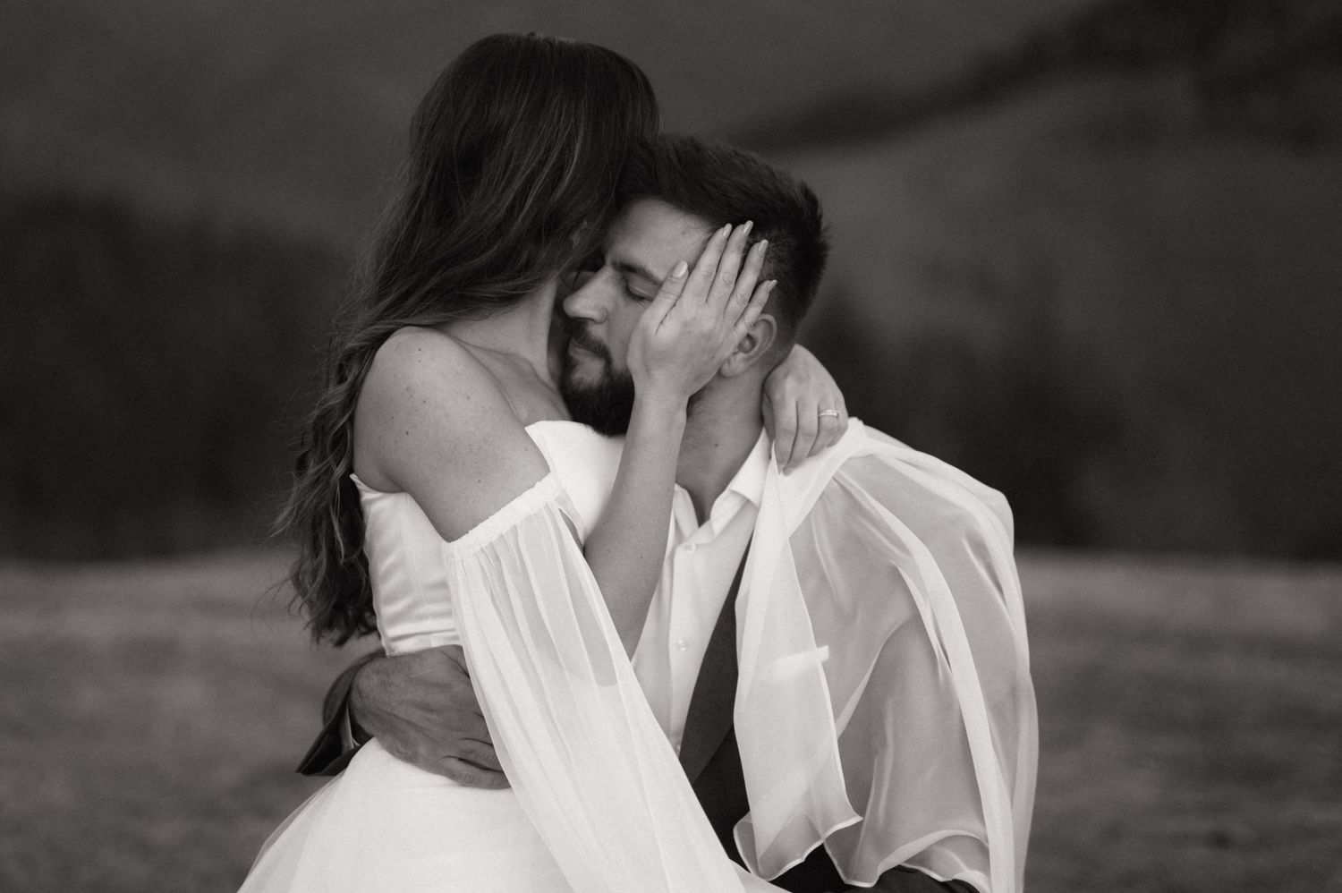 A romantic black and white photo series of a couple kissing and embracing outdoors.