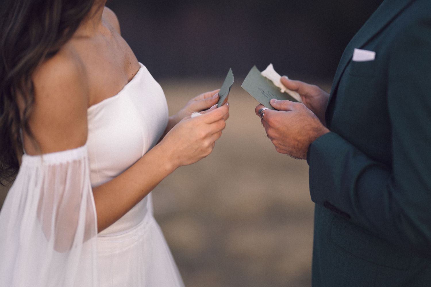 Close-up view of hands exchanging business cards during a professional meeting.